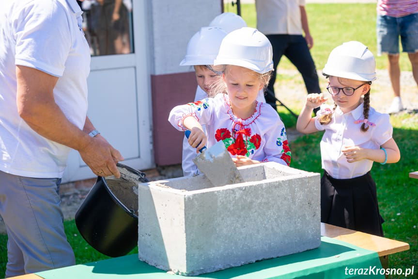 Dzieci ze Szkoły w Tylawie wmurowują kamień węgielny